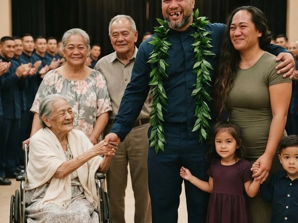 A retiring soldier in three leis with his wife and children, holding his grandmother hand in her wheelchair