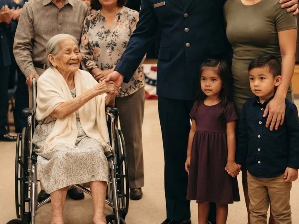 A retiring Guardian holding his grandmother hand in her wheelchair while his wife and children stand beside him